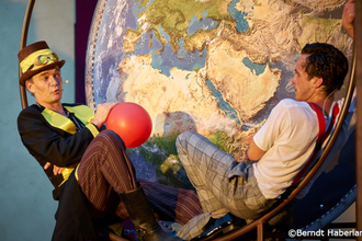 Zwei Schauspieler vor einer großen Weltkarte, einer hält einen roten Ballon. | © Kultur- und Sportamt Stadt Bietigheim-Bissingen