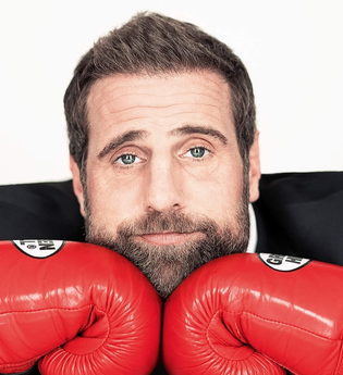 Künstler im Anzug mit roten Boxhandschuhen