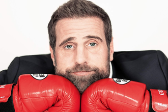 Künstler im Anzug mit roten Boxhandschuhen