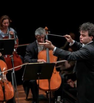 Dirigent leitet Orchester mit Streichern auf einer Bühne. | © Kammerkonzerte Schwäbisch Hall e.V.