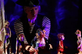 Schauspieler im kapitänskostüm mit Spielfiguren