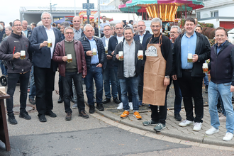 Gruppenbild Männer mit Bierkrug vor dem Karusell