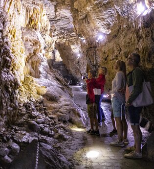 Besuchergruppe betrachten die Tropfstein-Formationen in der Eberstadter Tropfsteinhöhle | © Touristikgemeinschaft Odenwald e.V._Barbara Wagner