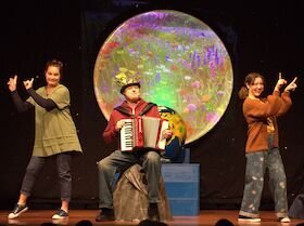 Foto Kindertheater Radelrutsch 3 Akteure im Vordergrund tanzend und mit Instrumenten im Hintergrund der Mond | © Kindertheater Radelrutsch