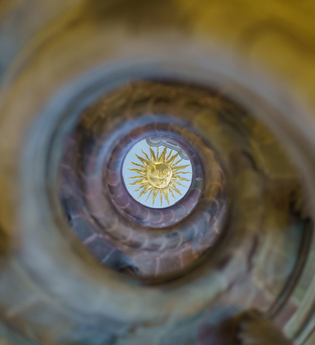Ein Blick in der Mitte durch die Wendeltreppe, oben an der Decke wird eine Sonne abgebildet. | © Björn Hänssler