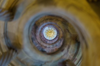 Ein Blick in der Mitte durch die Wendeltreppe, oben an der Decke wird eine Sonne abgebildet. | © Björn Hänssler