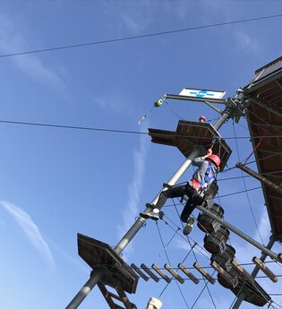 Auf dem Kletterturm klettert eine Person mit Absicherung | © Touristikgemeinschaft Hohenlohe e. V. | DAV Heilbronn