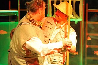 Zwei Schauspieler stellen eine Szene dar, Bär und Zoodirektor tanzen.