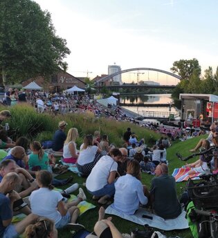 Platz vor der Fährlebühne mit Publikum auf dem ehemaligen BUGA  Gelände. Im Hintergrund die  Alte Reederei und der Neckar. | © Heilbronn Marketing GmbH