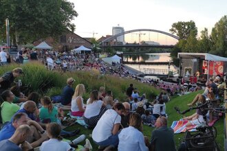 Platz vor der Fährlebühne mit Publikum auf dem ehemaligen BUGA  Gelände. Im Hintergrund die  Alte Reederei und der Neckar. | © Heilbronn Marketing GmbH