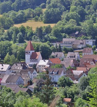Eine Luftaufnahme von der Ortschaft Morsbach mit Häusern, Kirche und Wald | © Touristikgemeinschaft Hohenlohe e. V. | Andi Schmid