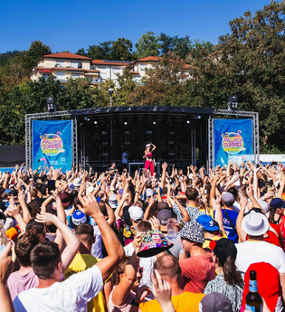 Eine  große Menschenmenge feiert gemeinsam vor einer Bühne. Die Künstlerin steht auf dieser Bühne. | © Mallorca Sommer Festival