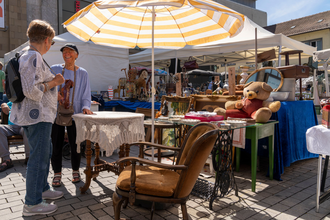 Besucherin und Standbetreiber verhandeln über einen Stuhl | © Heilbronn Marketing GmbH