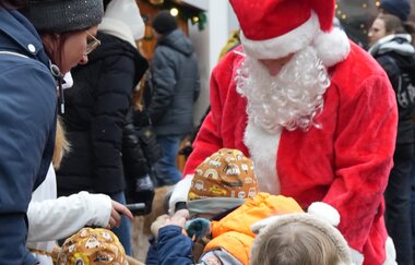 Weihnachtsmann der Geschenke an Kinder verteilt
