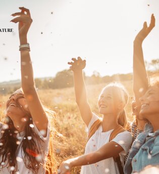 3 Mädchen bzw junge Frauen tanzen in einem Feld in der Natur | © Pangea - nature e. V.