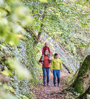 Eine Mutter wandert mit ihren zwei Töchtern durch den Wald | © Touristikgemeinschaft Hohenlohe e. V. | Florian Trykowski
