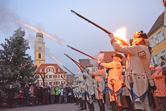 Die Historische Deutschorden Compagnie schießt auf dem Marktplatz mit ihren Gewähren in die Luft. Zuschauer schauen begeistert zu. | © Michael Weber-Schwarz