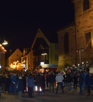 Weihnachtsmarkt bei Nacht mit Tannenbaum