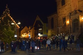 Weihnachtsmarkt bei Nacht mit Tannenbaum
