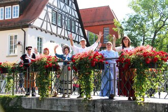 Gruppe Stadtführer stehen winkend auf einer Brücke