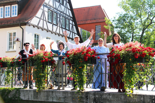 Gruppe Stadtführer stehen winkend auf einer Brücke