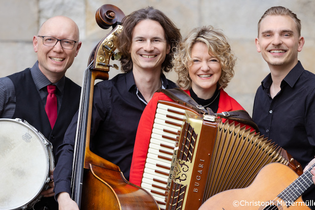 Vier Musiker mit Instrumenten, darunter ein Akkordeon, Kontrabass, Gitarre und Trommel, lächeln in die Kamera. | © Kultur- und Sportamt Stadt Bietigheim-Bissingen