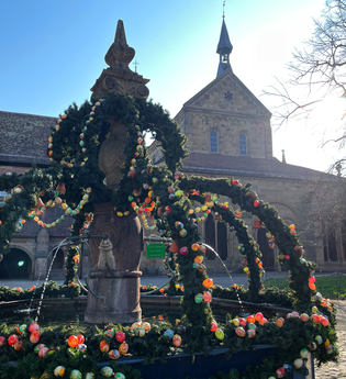 Geschmückter Osterbrunnen im Klosterhof im Hintergrund die Klosterkirche | © Stadt Maulbronn