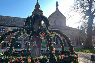 Geschmückter Osterbrunnen im Klosterhof im Hintergrund die Klosterkirche | © Stadt Maulbronn