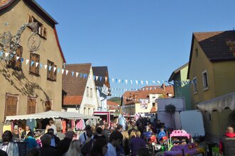 Viele Menschen bummeln durch die Rauenberger Innenstadt, zwischen den Häusern spannen Girlanden und an den Straßenrändern reihen sich links und rechts Imbissbuden und Verkaufszelte