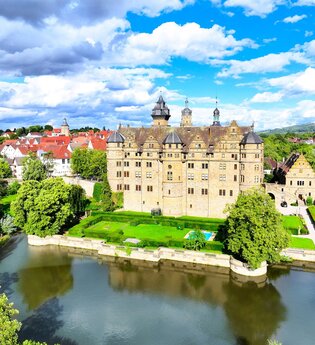 Das Schloss ist von einem Wassersee umgeben | © Touristikgemeinschaft Hohenlohe e. V. | Andi Schmid