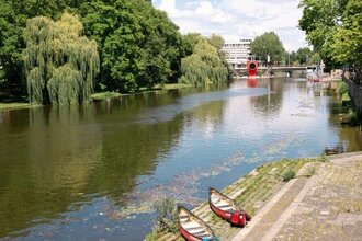4 Kanus liegen auf der letzten breiten Stufe direkt am Neckar. In weiter Ferne ist das rote one man house erkennbar, auf der gegenüberliegenden Seite säumen hohe Bäume das Ufer