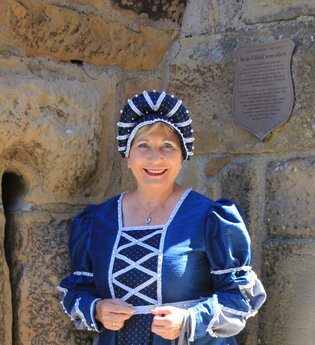 Burgführerin in blauem historischen Gewand