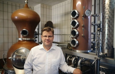 Fritz Lösch vor dem Brenngerät | © Touristikgemeinschaft Hohenlohe e. V. | Winzerstube Lösch