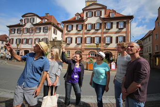 Eine Stadtführerin erklärt einer Gruppe die Sehenswürdigkeiten bei einer Führung. | © Stadtverwaltung Bad Mergentheim