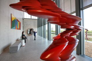 Zwei Besucher bewundern eine rote Skulptur und genießen den Ausblick ins Grüne | © Touristikgemeinschaft Hohenlohe e. V. | Firma Würth