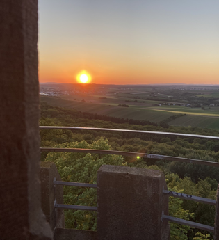 Sonnenuntergang in der Ferne mit Landschaft und Aussicht von einem Turm | © Nicole Betz