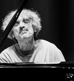 Ein Mann spielt konzentriert Klavier, seine Augen sind geschlossen. Das Bild ist in Schwarz-Weiß gehalten. | © Thomas Scheytt