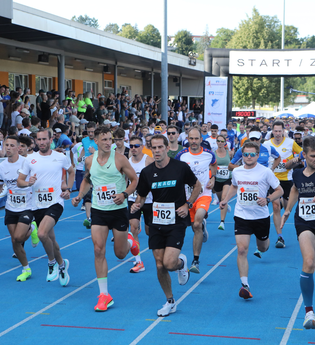 Gruppe von Läufern beim Start auf einer blauen Tartanbahn