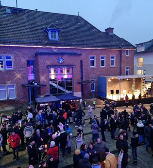 Weihnachtsmarkt auf dem Rathausplatz mit vielen Menschen und Ständen