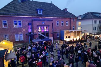 Weihnachtsmarkt auf dem Rathausplatz mit vielen Menschen und Ständen