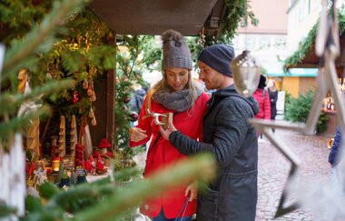 Ein Mann und eine Frau schauen sich selbstgemachte Handwerkskunst an. | © Stadt Bad Mergentheim