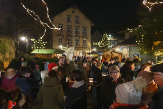 In weihnachtlicher Lichteratmosphäre stehen viele Besucher auf einem Marktplatz und sprechen miteinander. | © Gemeinde Blaufelden