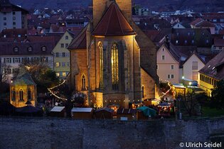 Blick auf den beleuchteten und geschmückten Weihnachtsmarkt um die Regiswindiskirche in Lauffen