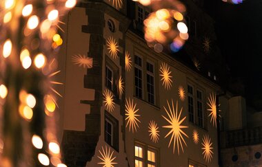An eine Fassade projezierte Sterne | © Touristikgemeinschaft Hohenlohe e. V. | Stadt Öhringen