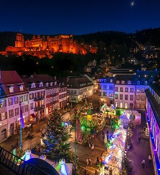 Bunte Weihnachtsbeleuchtung in einer Altstadt mit beleuchteten Häusern und einem Weihnachtsbaum. | © Heidelberg Marketing GmbH/Tobias Schwerdt