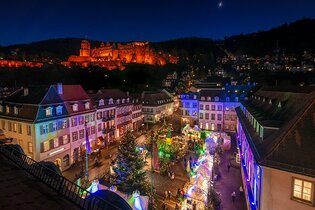 Bunte Weihnachtsbeleuchtung in einer Altstadt mit beleuchteten Häusern und einem Weihnachtsbaum. | © Heidelberg Marketing GmbH/Tobias Schwerdt