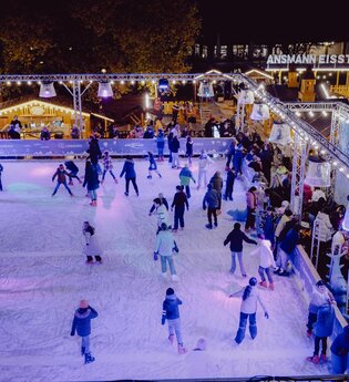 Eine Eislaufbahn mit vielen Eisläufern.