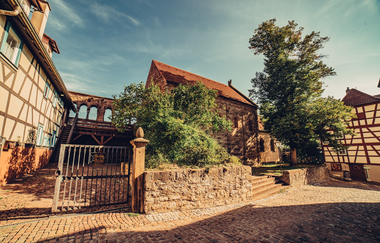 Blick in eine historische Fachwerkgasse. Außenansicht der Pfalzkapelle Bad Wimpfen. | © Stadt Bad Wimpfen