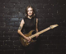 Yasi Hofer ist vor schwarzem Hintergrund mit Gitarre zu sehen | © Kulturforum Brackenheim e. V.