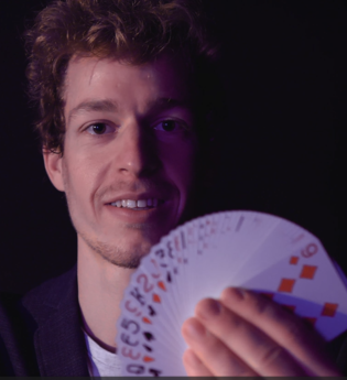 Der Zauberkünstler Max hält Spielkarten in der Hand